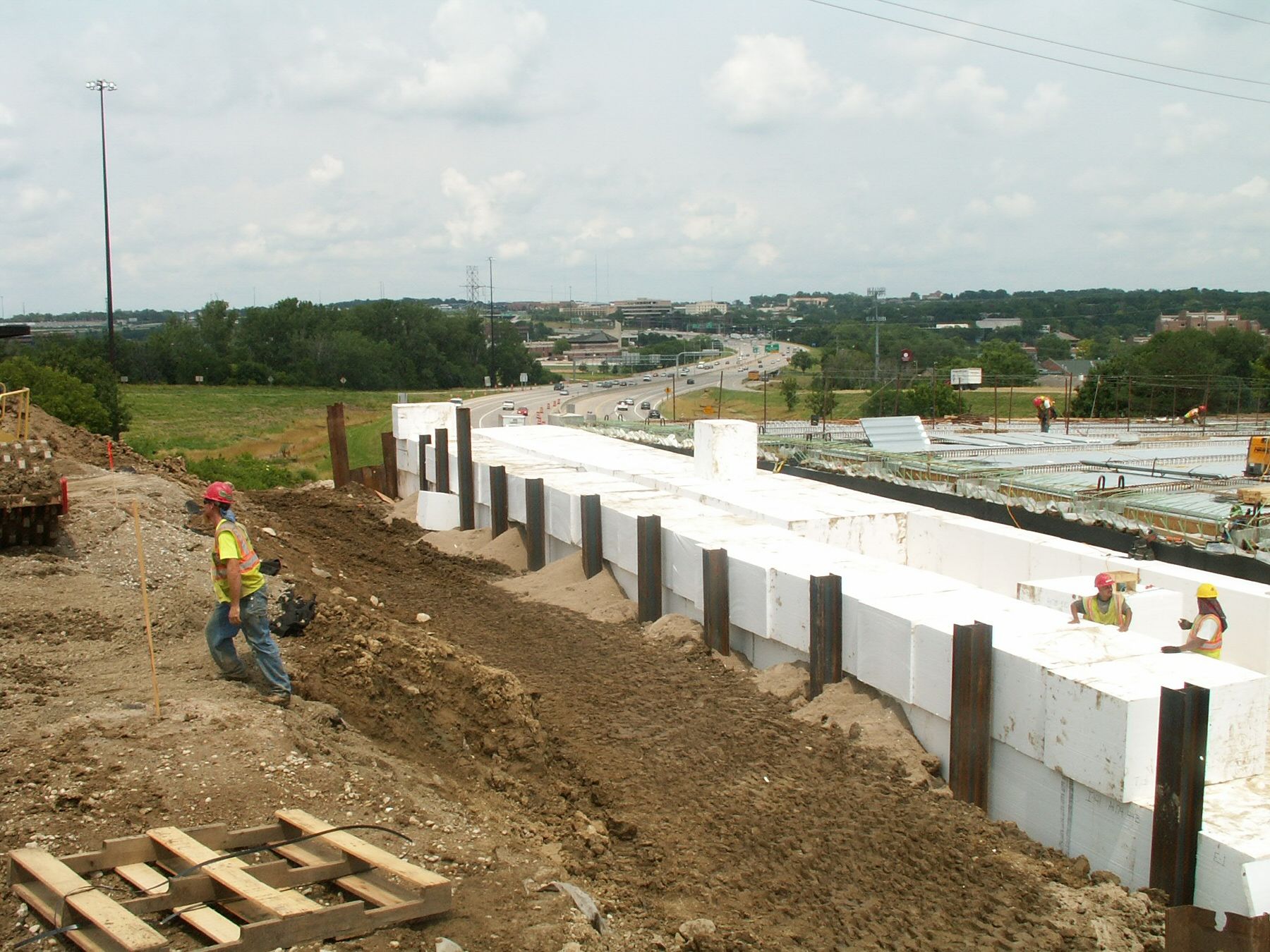 The existing 2:1 slope protection was removed and replaced by abutment walls allowing room for t he needed extra lane